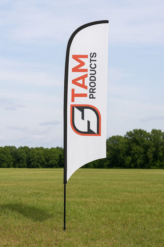 Stam Products branded arc flag banner with logo on white fabric in outdoor grassy field