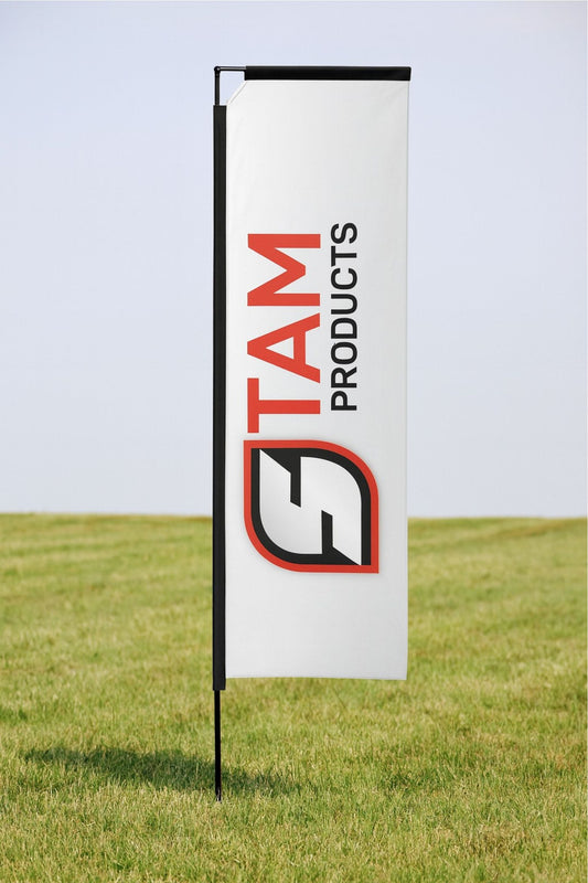 Outdoor telescopic flag banner with Stam Products branding on white fabric attached to a black folding aluminum frame in grassy field