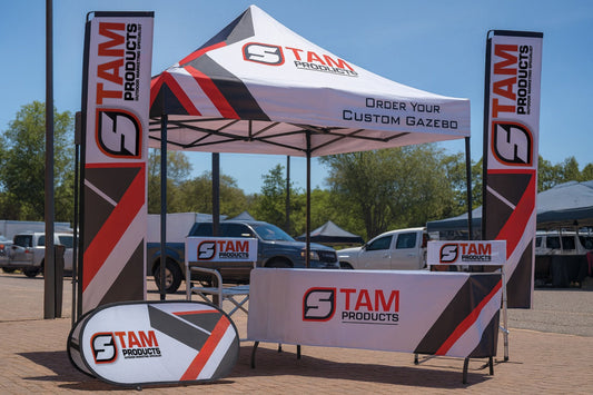Custom branded gazebo combo with printed canopy, flags, tablecloth, banner, and chairs for outdoor marketing events.