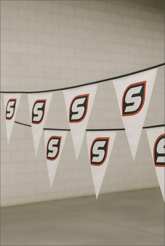Custom printed white PVC bunting with Stam Products branded logo on triangular flags hanging indoors