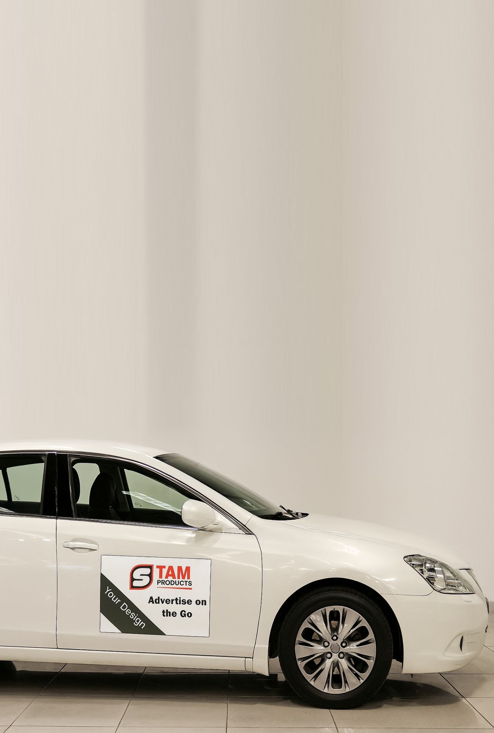 White car with Stam Products custom printed bespoke branded car magnet on the door advertising mobile marketing.